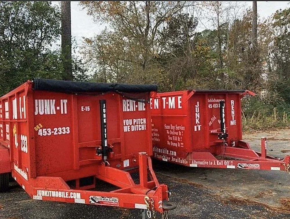 Junk It mobile dumpsters standing ready, lettered with the company name and phone number